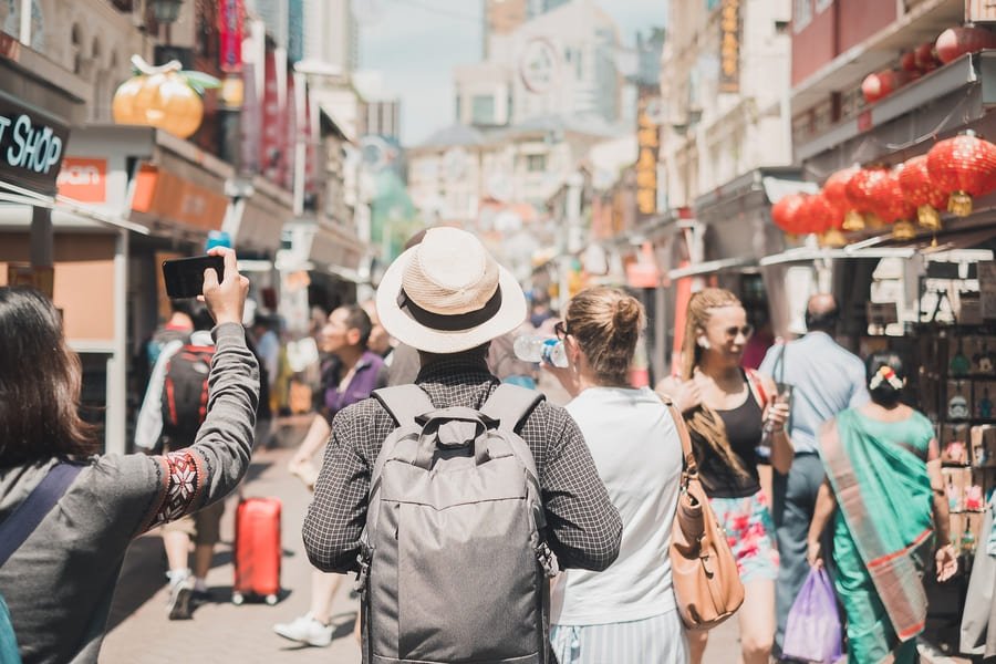 Viajeros explorando mercados locales y calles auténticas, representando la experiencia de un itinerario personalizado y turismo no masivo con Destino China.